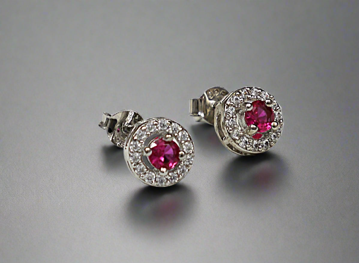 Pair of earrings with red gemstones on a white background