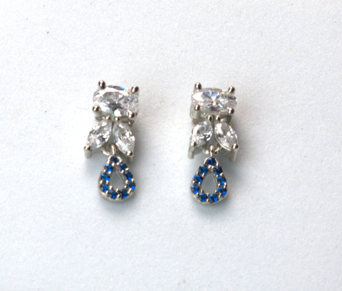 Pair of earrings with clear gemstones and blue accents on a white background