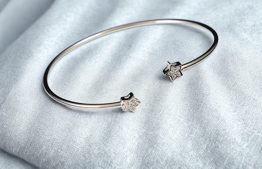 Silver bracelet and earrings on a light gray fabric background