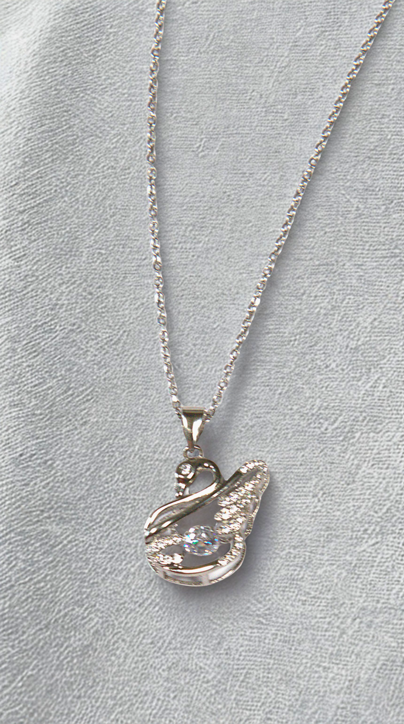 Silver necklace with a swan pendant on a light gray background