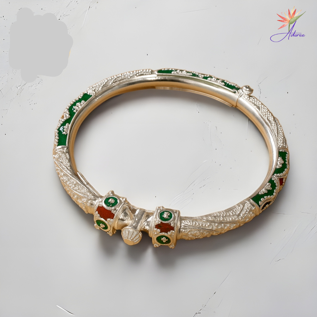 Decorative bangle with green and red stones on a light gray background