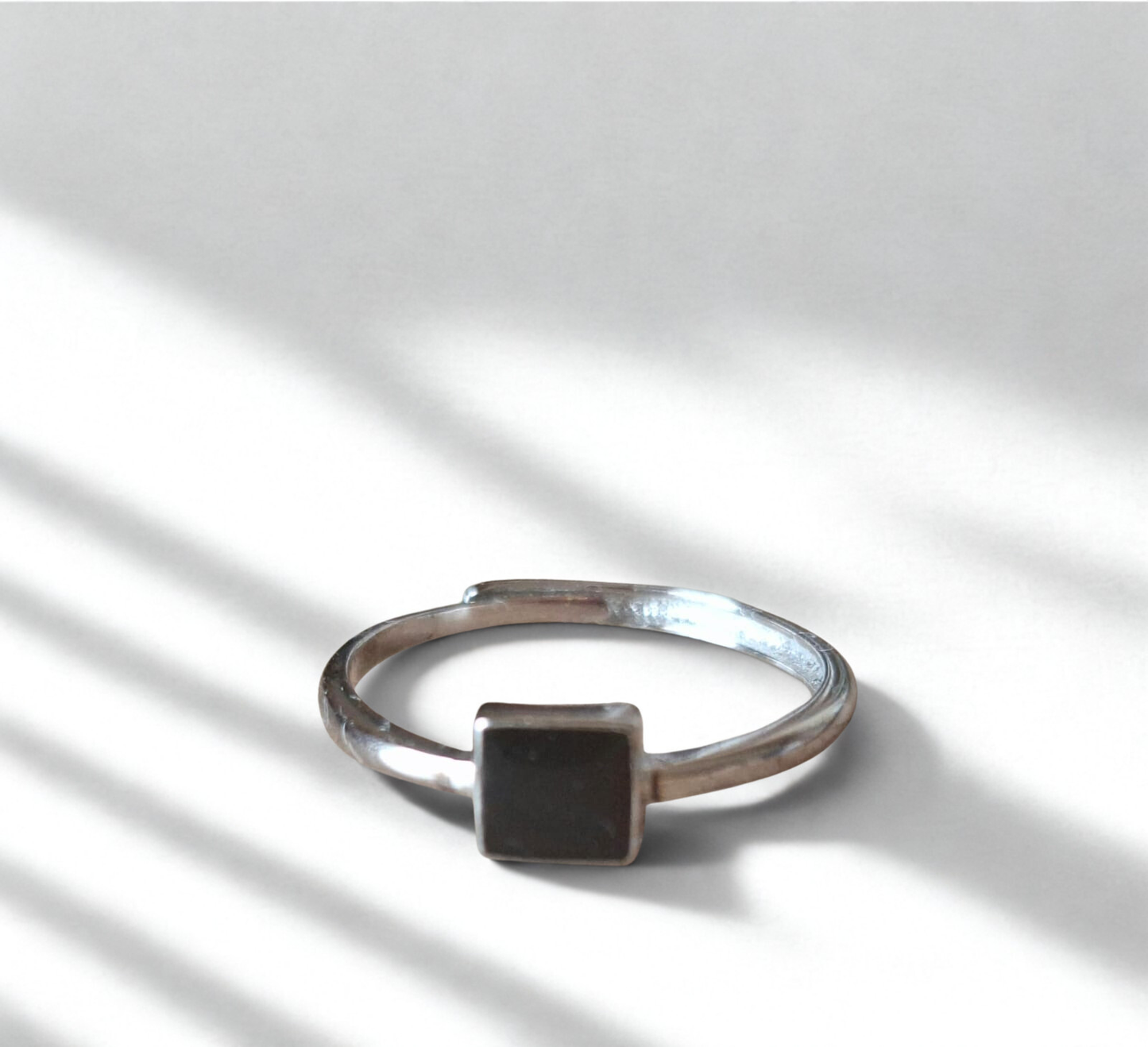 92.5 Silver ring with a black square stone on a light background