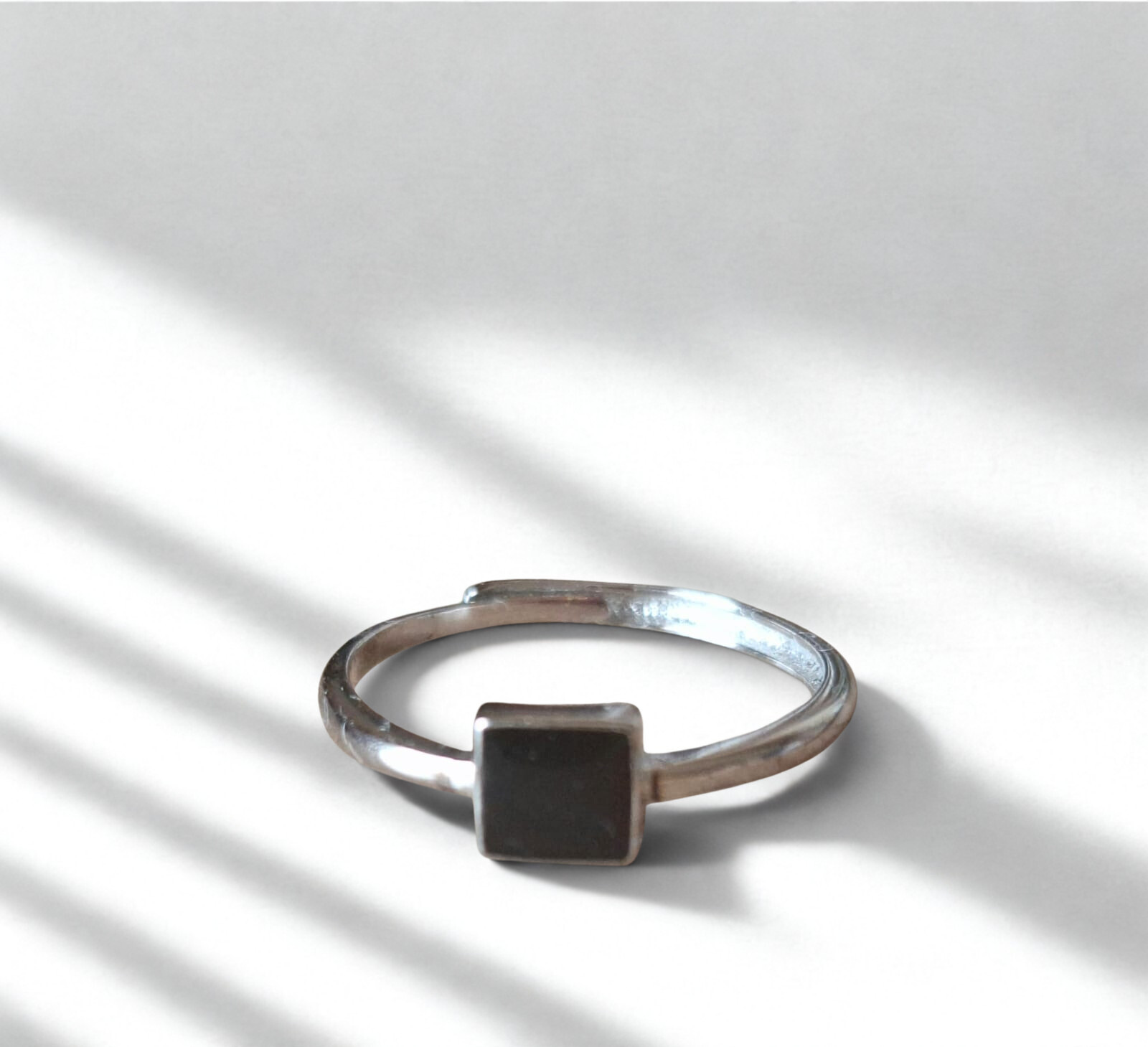 92.5 Silver ring with a black square stone on a light background