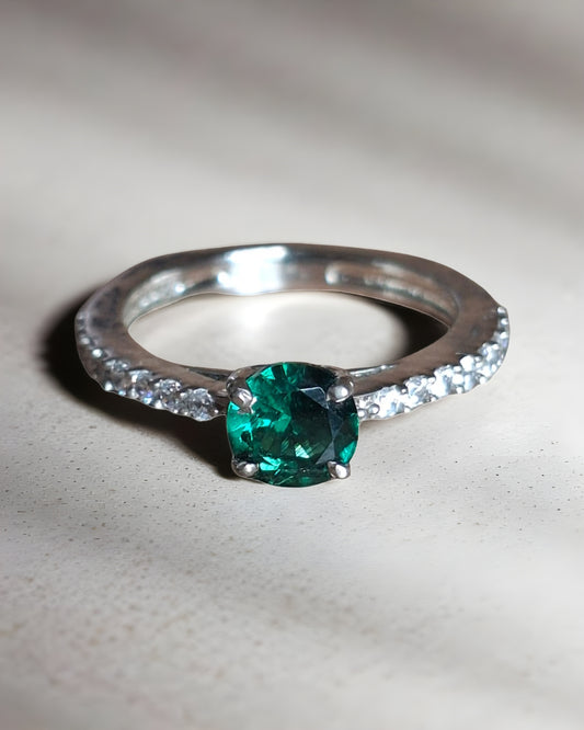  92.5 Silver ring with a green gemstone on a light background